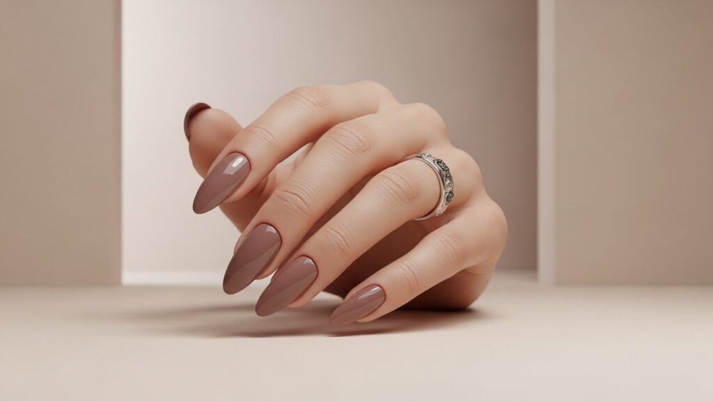 Mauve nude glossy winter nails with soft neutral winter background.
